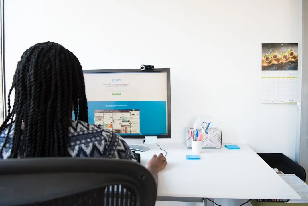 Someone sitting at a desk surrounded by multiple monitors displaying different ad platform interfaces and performance metrics